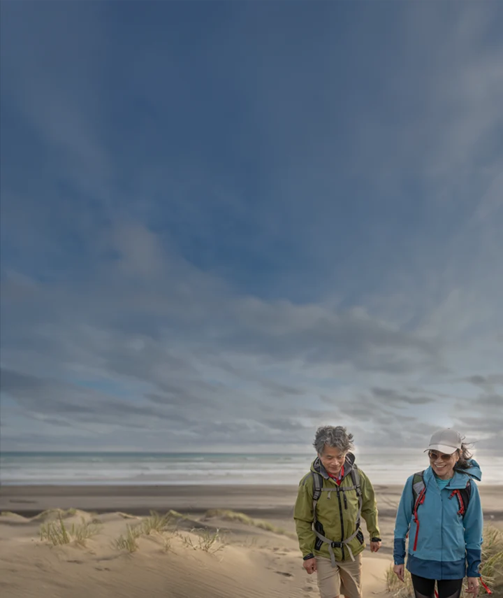 couple in jackets walking on beach
